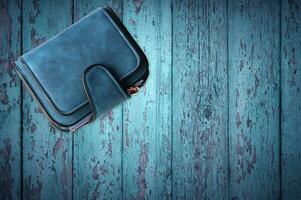 Blue women wallet isolated on blue wood background. photo