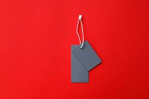 Two empty gray tags on a red background. Copy photo