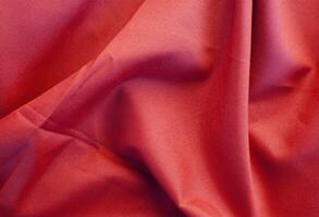 Red fabric with large folds abstract background. photo
