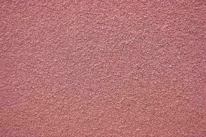 rosado horizontal pared cubierto con yeso textura. foto
