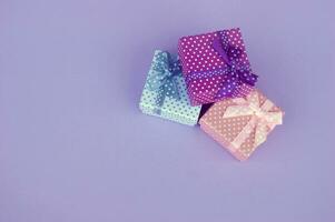 Three gifts on a lilac background. Copy space. photo