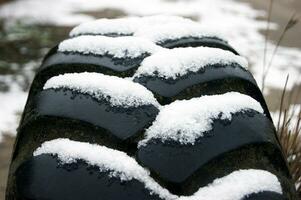 textura de un antiguo neumático con nieve en el surcos. foto