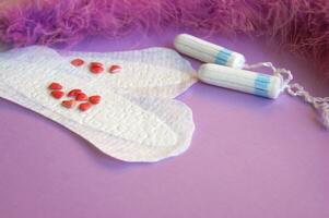 Menstrual pads and tampons on lilac background. photo