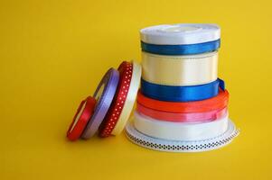 Spools of color ribbon on yellow background. photo