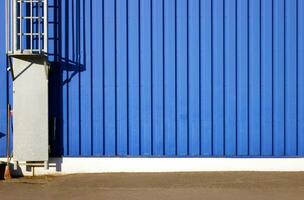 Blue background metal wall siding, cladding with stairs to the roof. photo