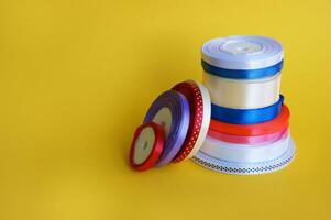 Spools of color ribbon on yellow background. photo