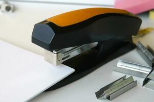 Classic black office stapler with documents. photo