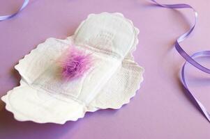 Menstrual pads with a fluff on a lilac background. photo