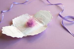 menstrual almohadillas con un pelusa en un lila antecedentes. foto