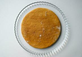 Round baked cake layer on a plate. photo