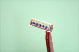 Closeup view with selective focus of disposable shaver isolated on abstract pink background. photo