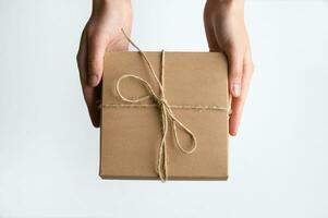 Girl holds out a gift craft box. photo