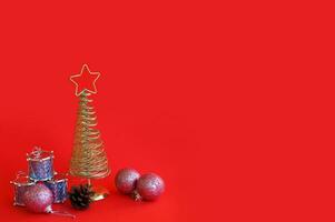 Golden metal Christmas tree with a star on top, red background. photo