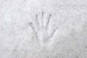 Handprint with fingers in white snow, background, texture. photo