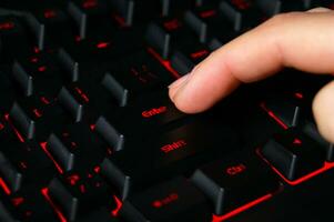 The macro of computer keyboard with finger pressing enter key. photo