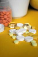 clasificado farmacéutico medicina pastillas, tabletas y cápsulas en amarillo antecedentes. foto