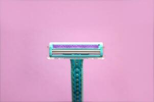 Closeup view with selective focus of disposable shaver isolated on abstract pink background. photo