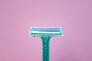 Closeup view with selective focus of disposable shaver isolated on abstract pink background. photo