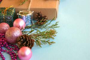 Christmas gift box, decoration and fir tree branch on light blue background. photo