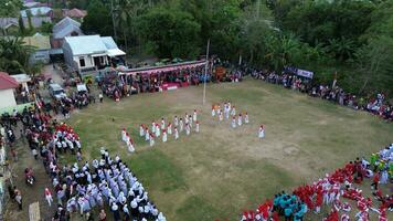 Aerial view of Indonesian flag lowering ceremony witnessed by villagers. Indonesia Independence Day photo