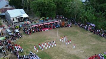 Aerial view of Indonesian flag lowering ceremony witnessed by villagers. Indonesia Independence Day photo