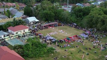 Aerial view of Indonesian flag lowering ceremony witnessed by villagers. Indonesia Independence Day photo