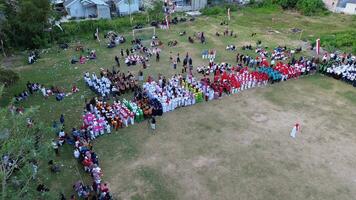 Aerial view of Indonesian flag lowering ceremony witnessed by villagers. Indonesia Independence Day photo