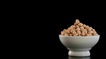 Bowl with chickpeas vegetables in rotation on black background video