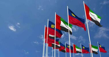 Liechtenstein y unido árabe emiratos, uae banderas ondulación juntos en el cielo, sin costura lazo en viento, espacio en izquierda lado para diseño o información, 3d representación video
