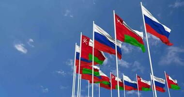 Oman e Russia bandiere agitando insieme nel il cielo, senza soluzione di continuità ciclo continuo nel vento, spazio su sinistra lato per design o informazione, 3d interpretazione video