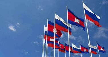 Cambogia e Russia bandiere agitando insieme nel il cielo, senza soluzione di continuità ciclo continuo nel vento, spazio su sinistra lato per design o informazione, 3d interpretazione video