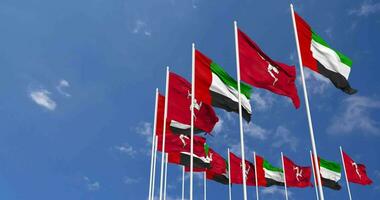 eiland van Mens en Verenigde Arabisch emiraten, uae vlaggen golvend samen in de lucht, naadloos lus in wind, ruimte Aan links kant voor ontwerp of informatie, 3d renderen video