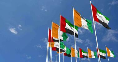 Marfil costa y unido árabe emiratos, uae banderas ondulación juntos en el cielo, sin costura lazo en viento, espacio en izquierda lado para diseño o información, 3d representación video