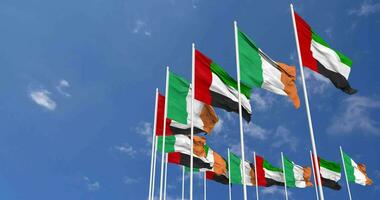 Irlanda y unido árabe emiratos, uae banderas ondulación juntos en el cielo, sin costura lazo en viento, espacio en izquierda lado para diseño o información, 3d representación video