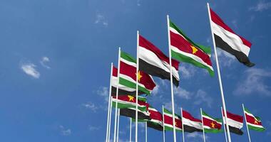 Suriname and Yemen Flags Waving Together in the Sky, Seamless Loop in Wind, Space on Left Side for Design or Information, 3D Rendering video