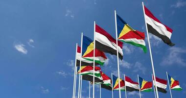 Seychelles and Yemen Flags Waving Together in the Sky, Seamless Loop in Wind, Space on Left Side for Design or Information, 3D Rendering video