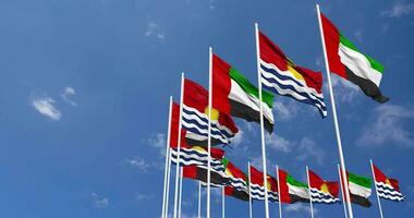 Kiribati y unido árabe emiratos, uae banderas ondulación juntos en el cielo, sin costura lazo en viento, espacio en izquierda lado para diseño o información, 3d representación video