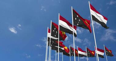 Papuasia nuevo Guinea y Yemen banderas ondulación juntos en el cielo, sin costura lazo en viento, espacio en izquierda lado para diseño o información, 3d representación video