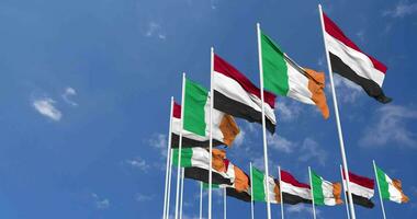 Irlanda y Yemen banderas ondulación juntos en el cielo, sin costura lazo en viento, espacio en izquierda lado para diseño o información, 3d representación video