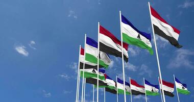 Lesotho and Yemen Flags Waving Together in the Sky, Seamless Loop in Wind, Space on Left Side for Design or Information, 3D Rendering video