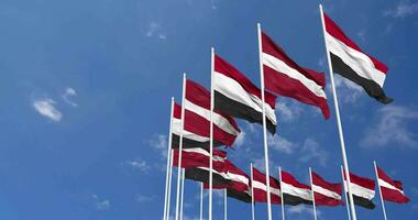 Latvia and Yemen Flags Waving Together in the Sky, Seamless Loop in Wind, Space on Left Side for Design or Information, 3D Rendering video