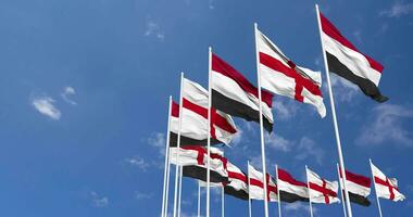 Inghilterra e yemen bandiere agitando insieme nel il cielo, senza soluzione di continuità ciclo continuo nel vento, spazio su sinistra lato per design o informazione, 3d interpretazione video