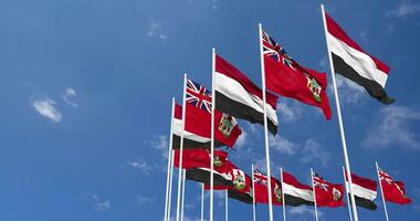 Bermuda and Yemen Flags Waving Together in the Sky, Seamless Loop in Wind, Space on Left Side for Design or Information, 3D Rendering video