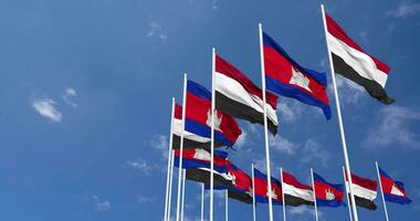 Cambogia e yemen bandiere agitando insieme nel il cielo, senza soluzione di continuità ciclo continuo nel vento, spazio su sinistra lato per design o informazione, 3d interpretazione video
