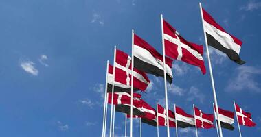 Denmark and Yemen Flags Waving Together in the Sky, Seamless Loop in Wind, Space on Left Side for Design or Information, 3D Rendering video