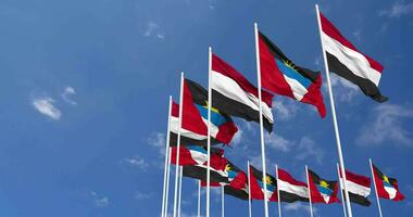 Antigua and Barbuda and Yemen Flags Waving Together in the Sky, Seamless Loop in Wind, Space on Left Side for Design or Information, 3D Rendering video