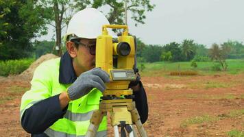 Surveyor engineer with equipment theodolite or total positioning station on the construction site. video