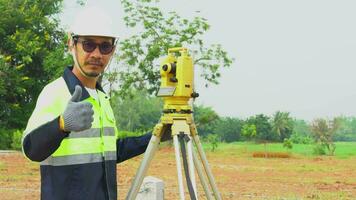 Azië landmeter ingenieur met uitrusting theodoliet Aan de bouw plaats. video