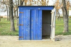 Public toilet in a street park. Blue wooden toilet, restroom. photo