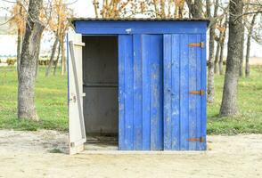 Public toilet in a street park. Blue wooden toilet, restroom. photo